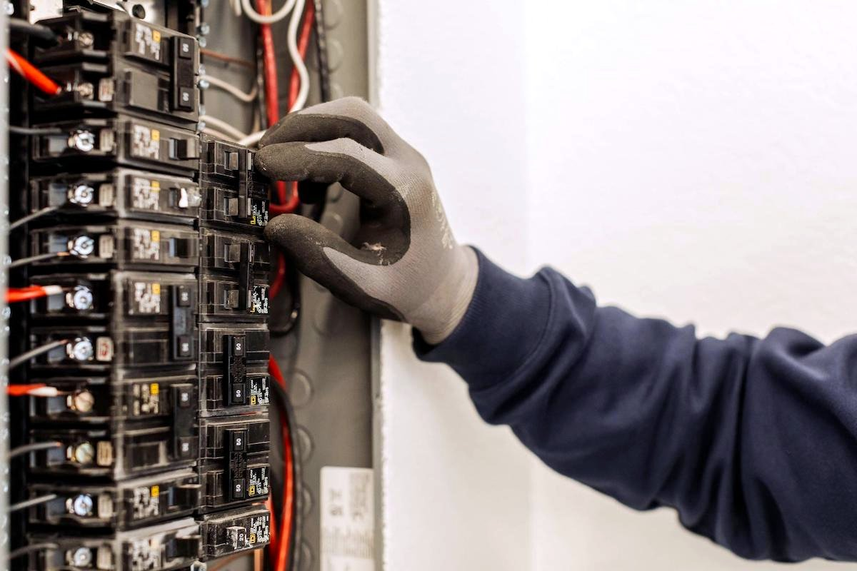 Electrician working inside an opened electrical switchboard